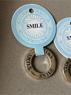 NWT six infinity circle imprinted with smile. Layered in sterling silver.